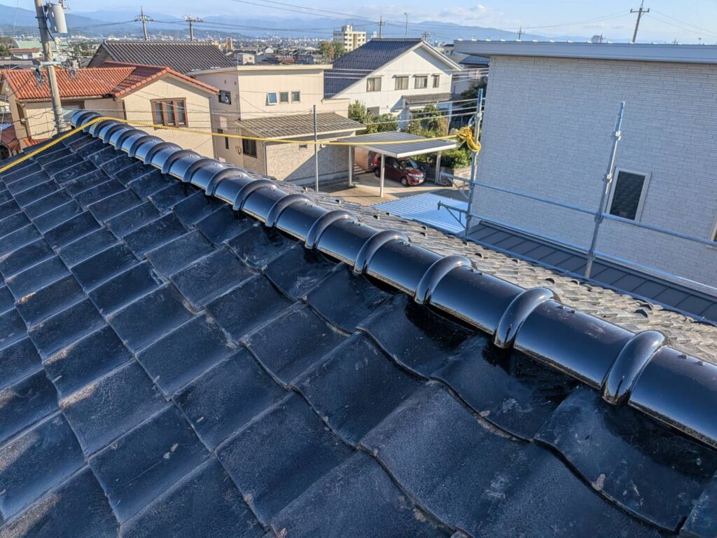 施工後は、既存瓦を再利用しながら、大屋根全面の下地・防水層・瓦の固定状態を整えることができました。

施工前に見られた銅線の切れや緩みに対して平瓦を締め直し、湿りが確認された下地には構造用合板と新しいルーフィングを施工。さらに棟も土台から積み直し、ハイロールを取り付けています。

「できるだけ費用を抑えたい」というご要望に対し、使える瓦を活かしながら必要な部分を更新する工事となりました。