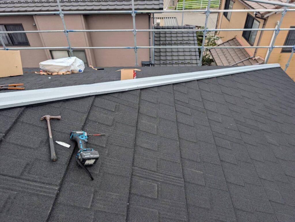 屋根の棟部分には、通し用棟水切りを取り付けました。

棟水切りは、棟用板金の下地材としての役割に加え、水の流れを考慮して棟部分を納めるための部材です。

