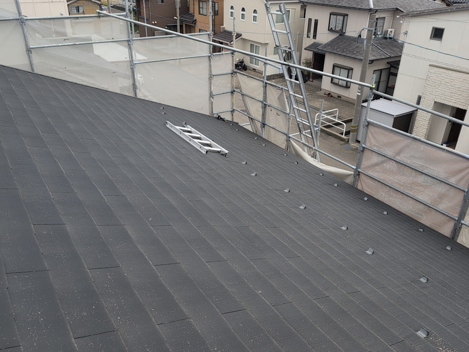 築25年が経過したスレート屋根は、長年の紫外線や雨の影響によって表面が劣化し、屋根材そのものが脆くなっていました。

今回、目立った割れは確認されませんでしたが、割れていないからといって屋根が良好な状態とは限りません。

脆くなったスレートは、外部からの衝撃や積雪などの負荷によって割れが発生しやすくなる可能性があります。

特に石川県では、冬の積雪や年間を通じた降雨も考慮する必要があります。

築25年が経過したスレート屋根は、長年の紫外線や雨の影響で劣化し、屋根材そのものが脆くなっていました。

今回、目立った割れは確認されませんでしたが、割れていないからといって良好な状態とは限りません。

脆くなったスレートは、外部からの衝撃や積雪などの負荷によって割れる可能性があります。特に石川県では、冬の積雪や年間を通じた降雨も考慮する必要があります。

今回は屋根全体の劣化状況を踏まえ、新しい防水層と屋根材を重ねる方法を採用しました。割れが発生してから対処するのではなく、現状を確認した段階で今後の維持管理を考えたことが、今回の工事につながっています。