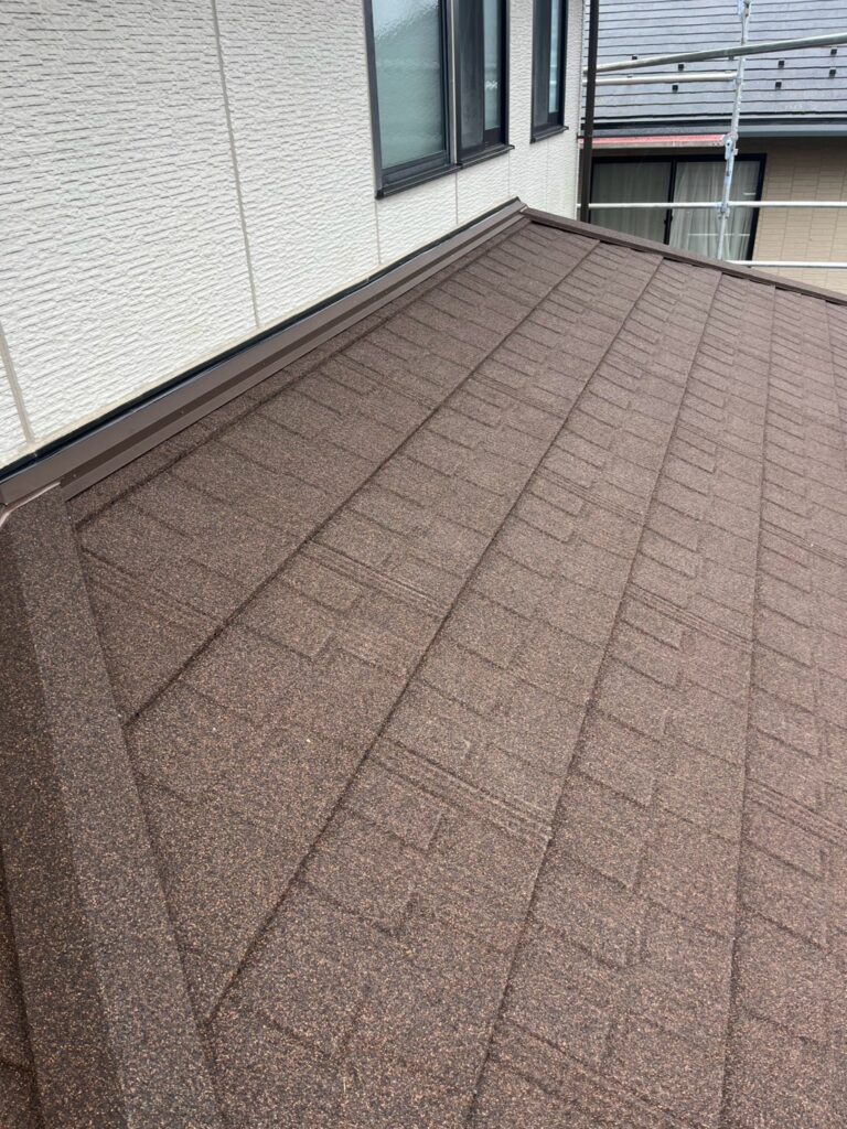 最後に、木下地を設けた取り合い部分へ板金を取り付けました。

屋根と他の部材が接する部分は、雨水が集中したり、風によって雨が吹き込んだりする可能性があります。

そのため、板金の重なりや水の流れる方向を考慮し、雨水を適切に排出できる納まりが重要です。

屋根材だけでなく、こうした接合部分まで防水対策を行うことで、屋根全体の防水性向上につなげました。