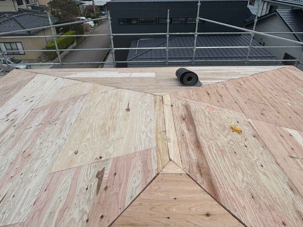 続いて、既存のAT屋根の上から構造用合板を張りました。

構造用合板は、新しい屋根材を施工するための下地となる材料です。

今回のように既存屋根の劣化が進んでいる場合、新たな下地を設けることで、屋根材を安定して固定するための施工面を確保できます。

合板の配置や固定が不十分だと、その上に施工する屋根材の安定性にも影響するため、重要な工程です。