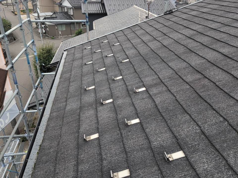 屋根表面にはコケが発生しており、特に軒先付近で目立つ状態でした。

コケは水分が残りやすい場所などで発生し、屋根表面の乾燥を妨げる場合があります。

コケだけで全面改修が必要とは限りませんが、今回は割れや欠けも確認されていました。

そのため、表面の洗浄だけでなく、屋根材の保護機能と外観を総合的に見直す改修を行いました。