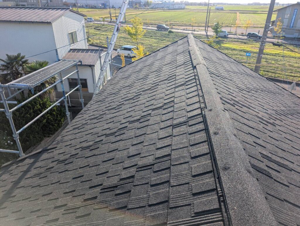 最後に、屋根の頂部となる棟部分へ棟板金を取り付けました。

棟は左右の屋根面が合わさる部分のため、屋根材を葺くだけでは仕上がりません。棟部分を板金で適切に納めることで、屋根の頂部から雨水が入り込むことを防ぎます。

Tルーフ、通し水切り、棟板金までそれぞれの納まりを確認し、屋根全体の施工を完了しました。